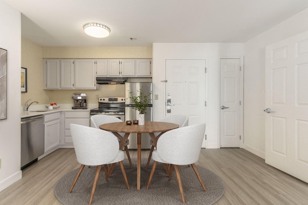 a kitchen and dining room with white cabinets and a table and chairs